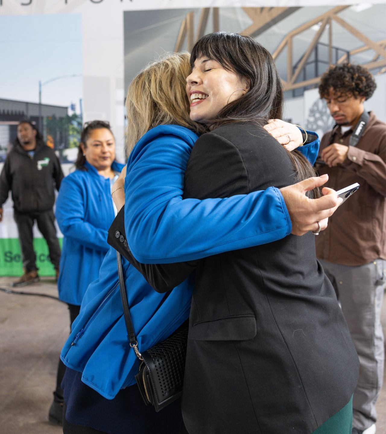 Two supporters embracing at the Roots for Youth groundbreaking celebration
