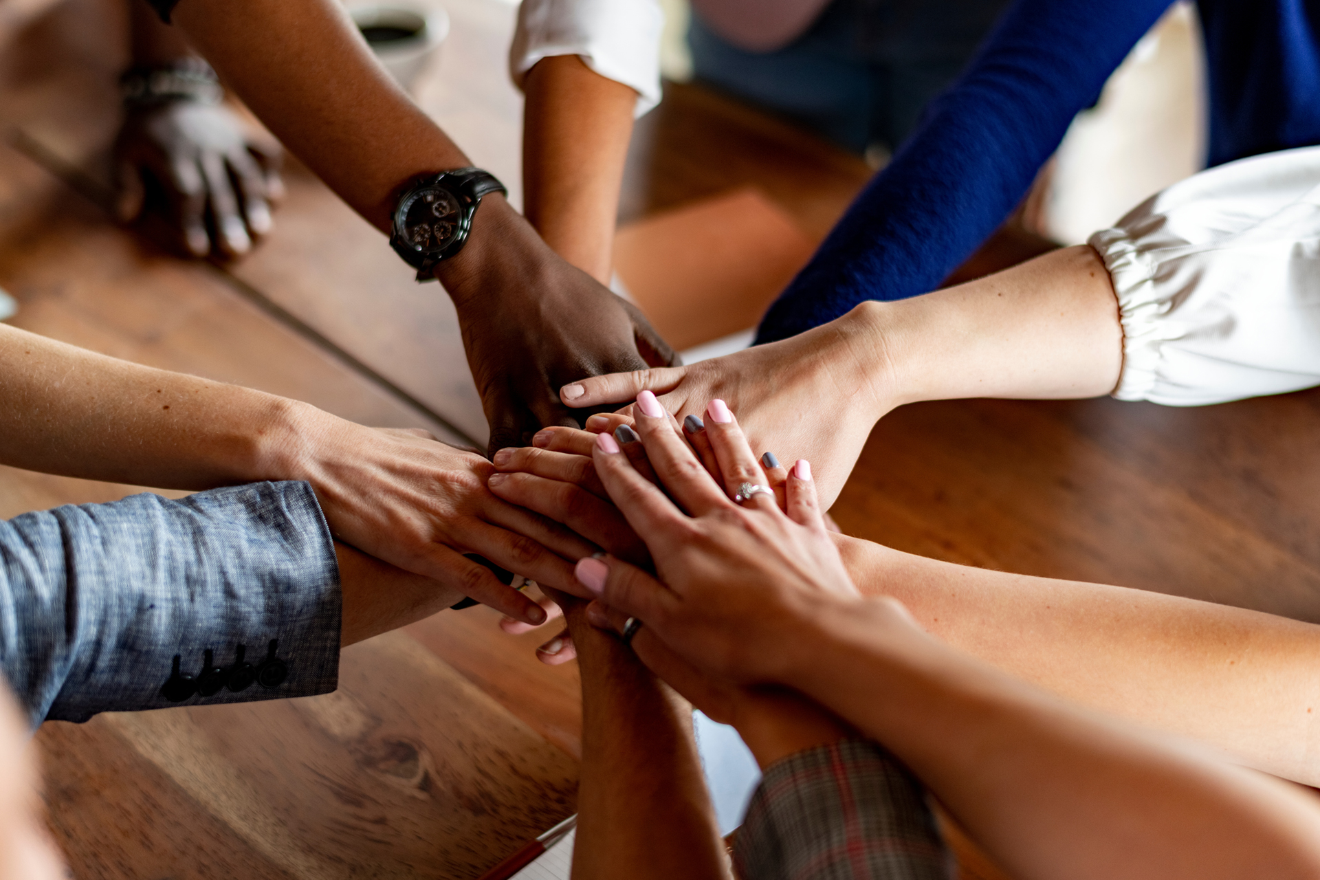 Hands joined over wooden table